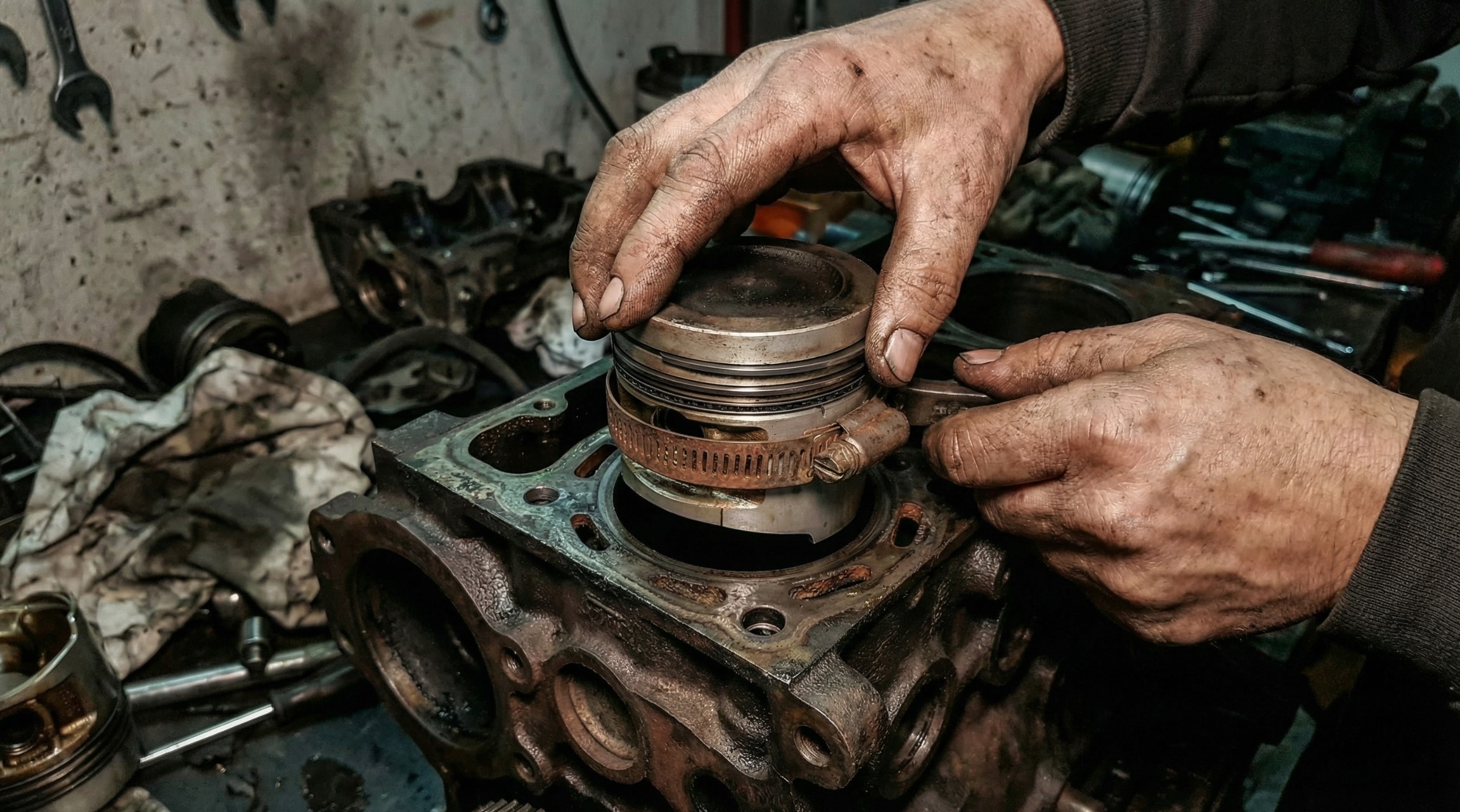 Installing piston into R180 diesel engine cylinder block using ring compressor tool