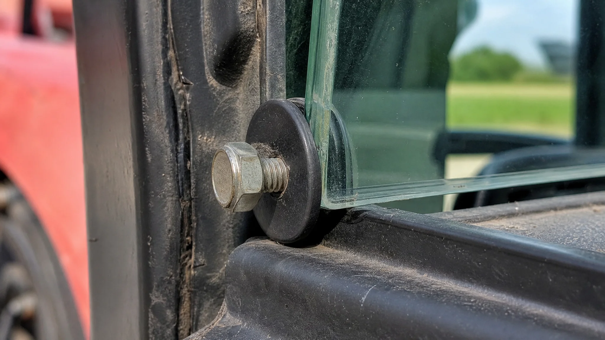 Detailed view of rubber dampers installed on tractor side glass hinges